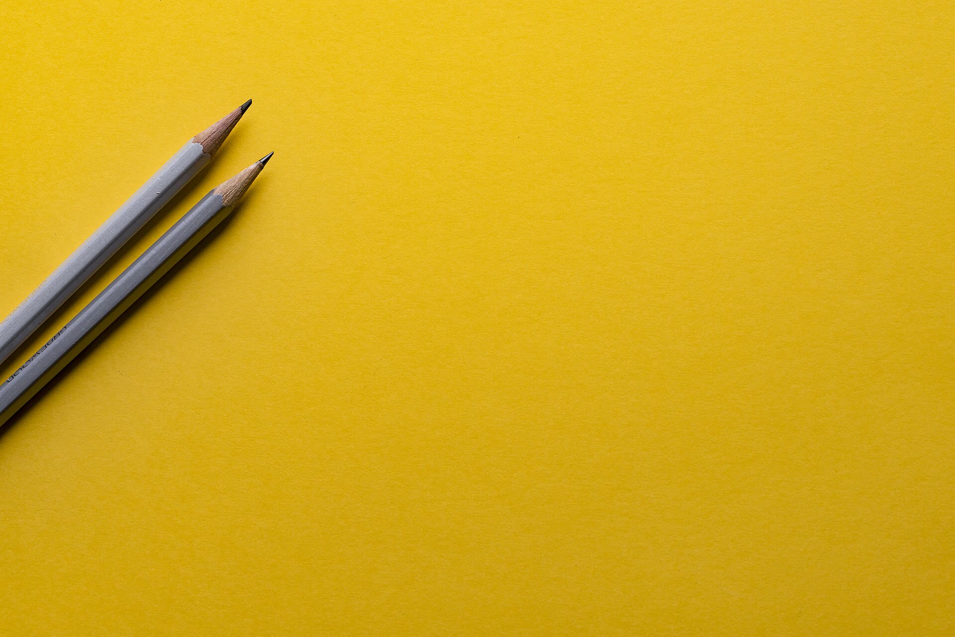 Dois lápis sobre um fundo amarelo